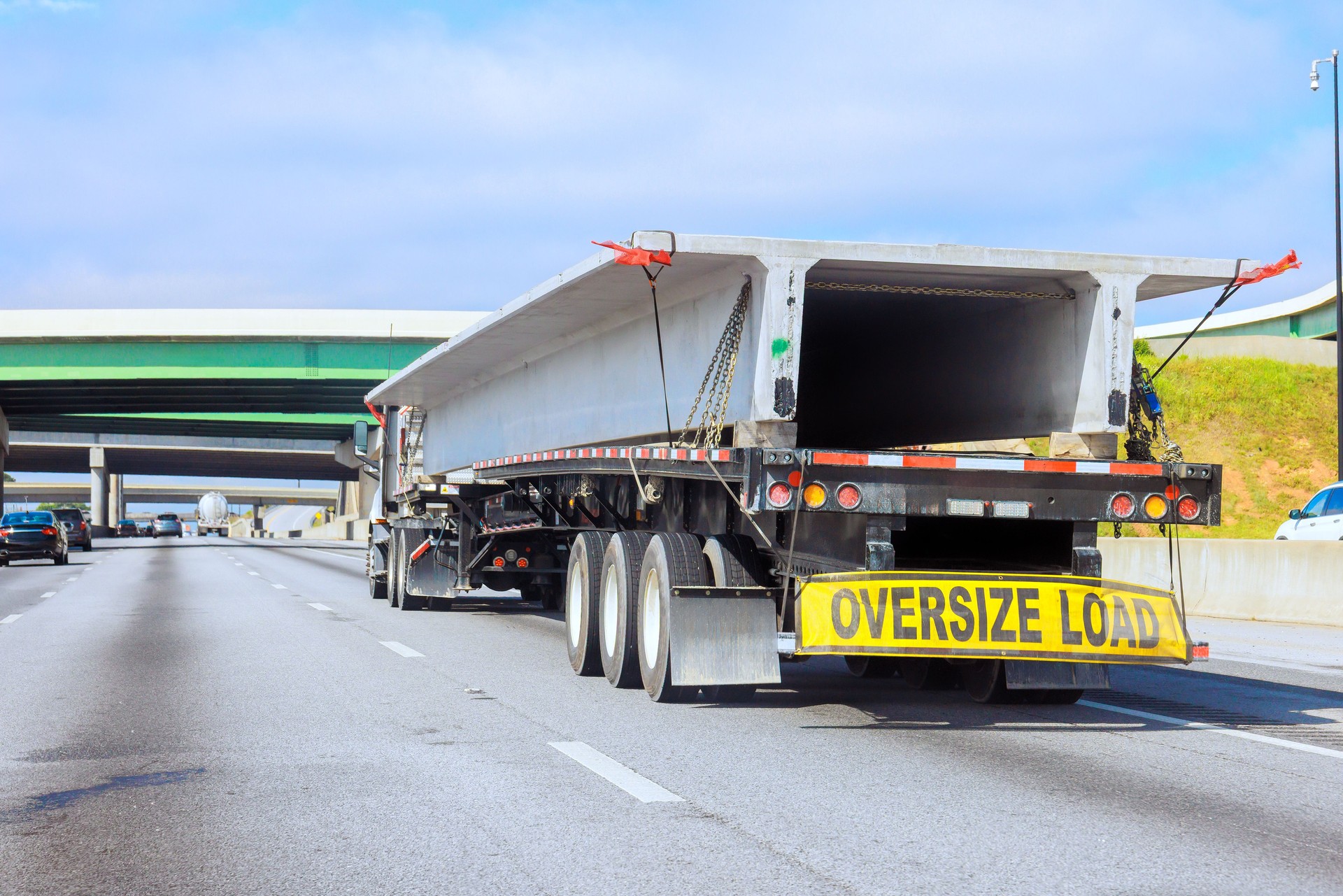 Transporting oversize load on highway with truck carries long concrete slabs